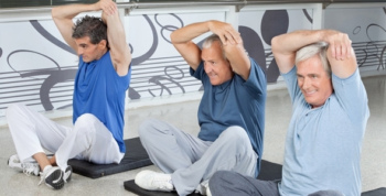 Drie mannen die zittend hun armen stretchen