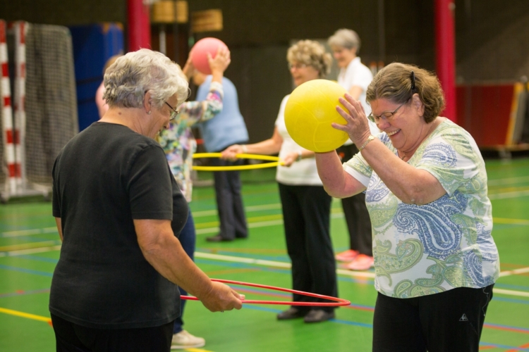 Twee dames sportend met een hoepel en bal